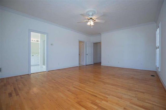 spare room featuring a ceiling fan, light wood-type flooring, ornamental molding, and baseboards