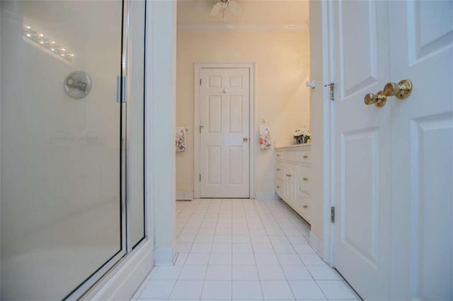 bathroom featuring an enclosed shower, tile patterned floors, ornamental molding, and baseboards