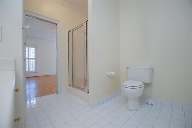 full bath with tile patterned floors, a stall shower, toilet, baseboards, and crown molding