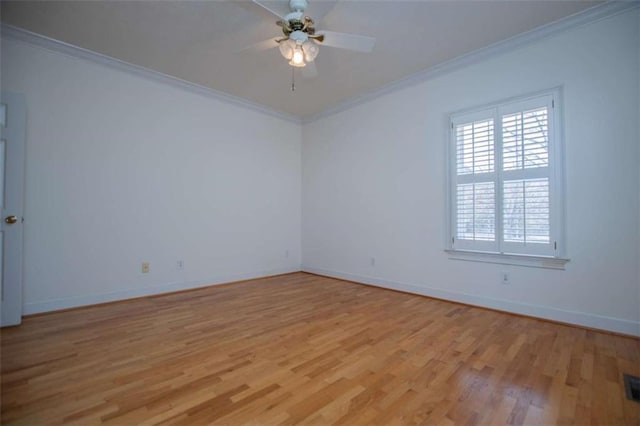 spare room with crown molding, light wood-type flooring, ceiling fan, and baseboards