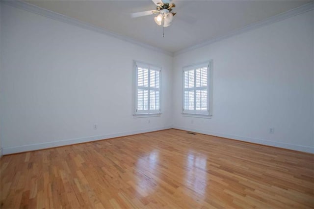 empty room with crown molding, light wood-style floors, a ceiling fan, and baseboards