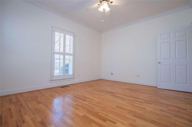 spare room with crown molding, light wood finished floors, ceiling fan, and baseboards