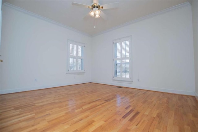 empty room with crown molding, light wood-type flooring, baseboards, and a ceiling fan