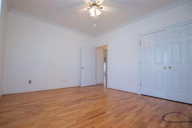 unfurnished bedroom featuring light wood-style flooring, ornamental molding, baseboards, a closet, and ceiling fan