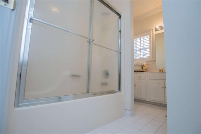bathroom featuring tile patterned floors, crown molding, vanity, and shower / bath combination with glass door