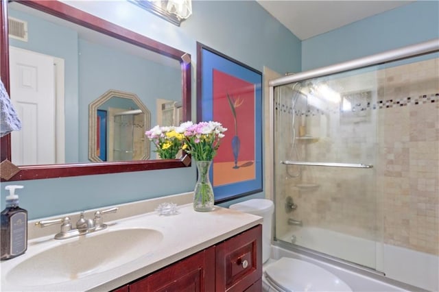 bathroom with vanity, enclosed tub / shower combo, toilet, and visible vents