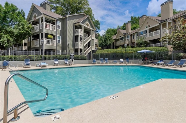 community pool featuring a patio area and fence