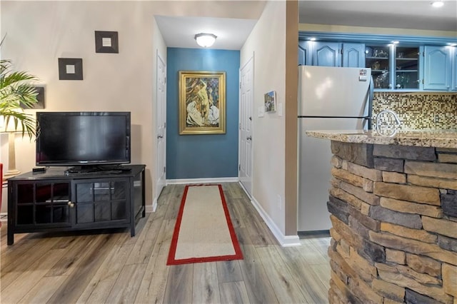 interior space with baseboards and light wood finished floors