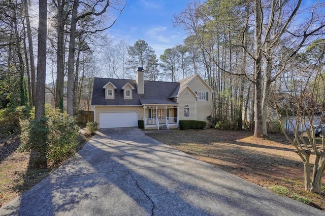 cape cod-style house featuring covered porch and a garage