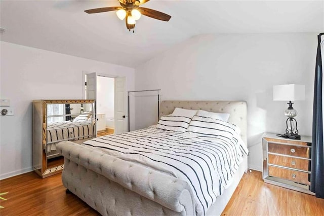 bedroom with hardwood / wood-style floors, ceiling fan, and vaulted ceiling