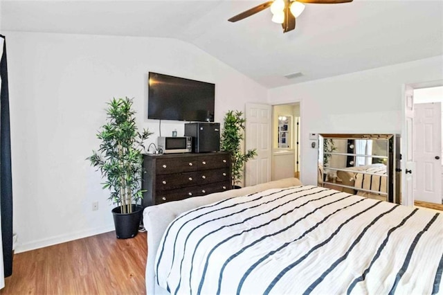 bedroom featuring ceiling fan, lofted ceiling, and light hardwood / wood-style flooring