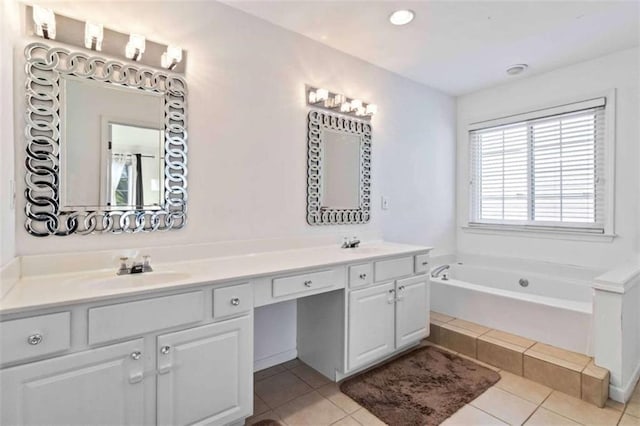 bathroom with tile patterned flooring, a relaxing tiled tub, and vanity