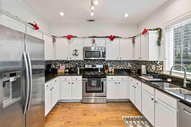 kitchen featuring plenty of natural light, sink, white cabinetry, and stainless steel appliances