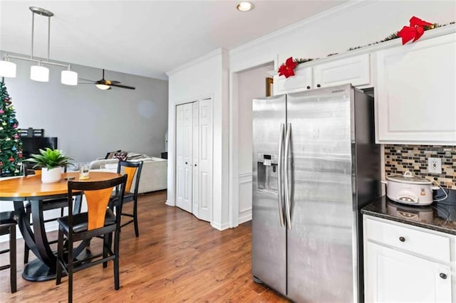 kitchen featuring white cabinetry, ceiling fan, stainless steel refrigerator with ice dispenser, backsplash, and light hardwood / wood-style floors