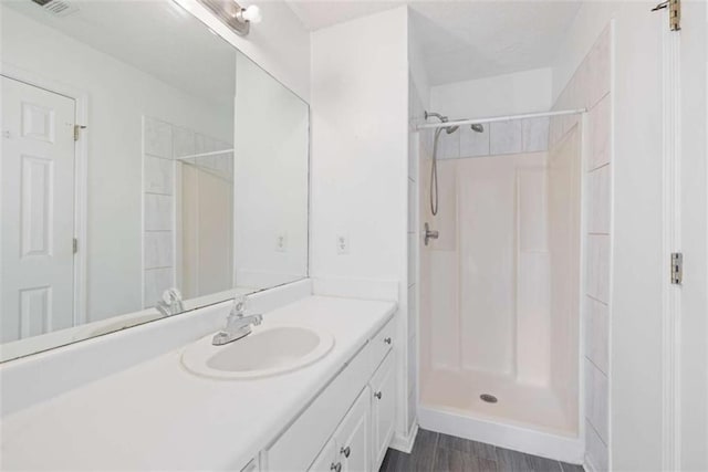 bathroom featuring walk in shower and vanity