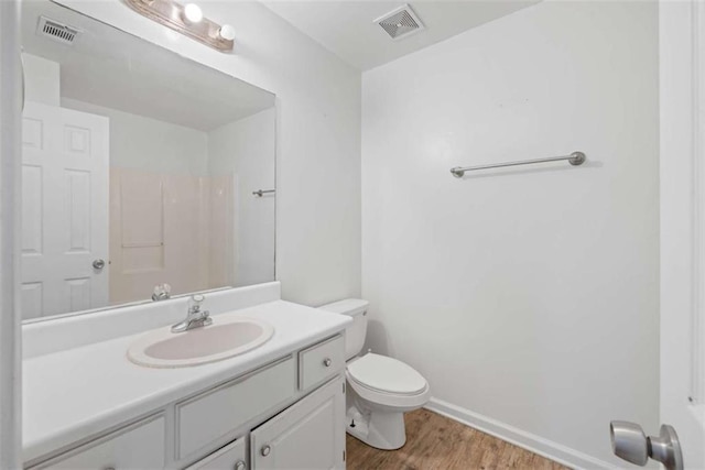 bathroom featuring vanity, wood-type flooring, and toilet