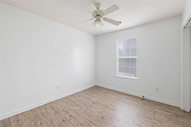 empty room with ceiling fan, a textured ceiling, and light wood-type flooring