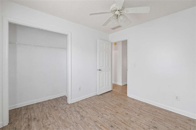 unfurnished bedroom with ceiling fan, light hardwood / wood-style floors, and a closet