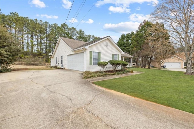 view of side of property featuring a garage and a lawn