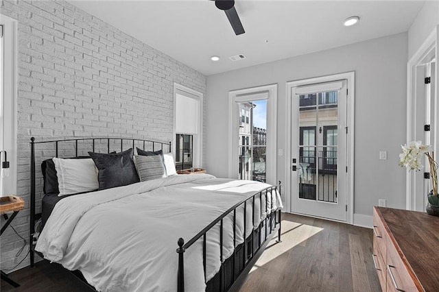 bedroom featuring visible vents, brick wall, ceiling fan, dark wood-type flooring, and access to outside