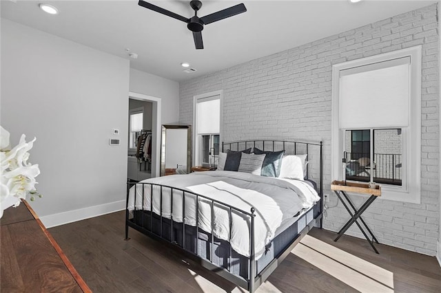 bedroom with brick wall, baseboards, and wood finished floors