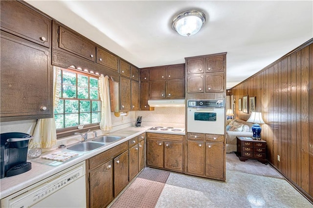 4581 Newcastle Cir, Lithonia, GA 30038 - kitchen with white appliances, wood walls, light countertops, under cabinet range hood, and dark brown cabinetry