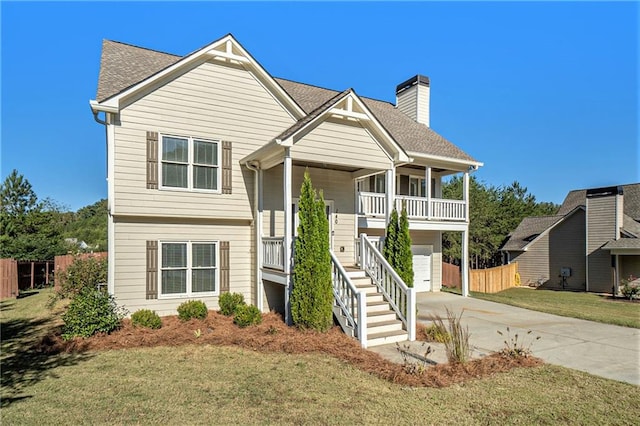 view of front facade with a front lawn, covered porch, and a garage