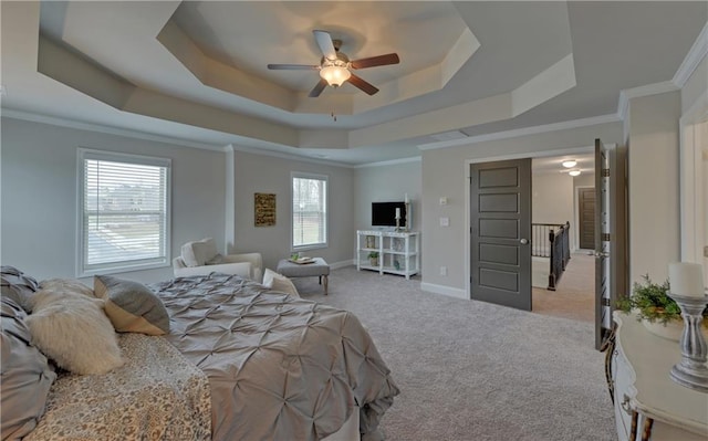 bedroom featuring light carpet, a tray ceiling, ceiling fan, and ornamental molding