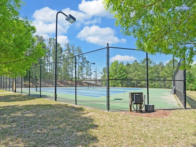 view of sport court with a lawn