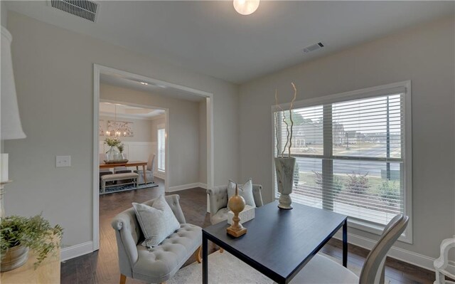 home office featuring a wealth of natural light, dark hardwood / wood-style flooring, and a notable chandelier