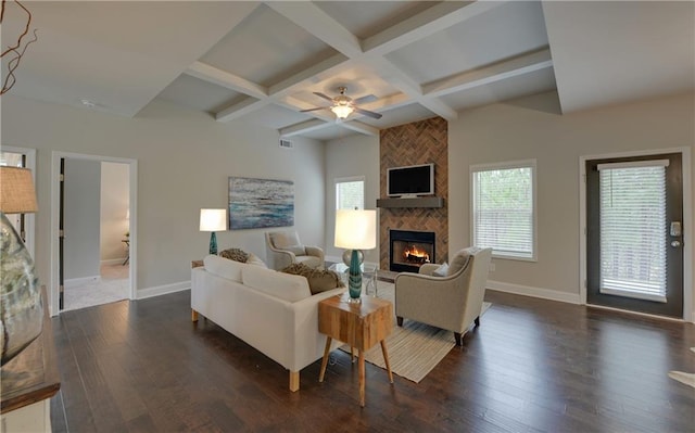 living room with coffered ceiling, beam ceiling, dark hardwood / wood-style flooring, and a tiled fireplace