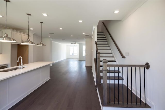 kitchen featuring pendant lighting, white cabinets, dark hardwood / wood-style floors, and sink