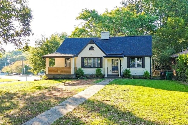 view of front of property with a chimney, fence, and a front lawn