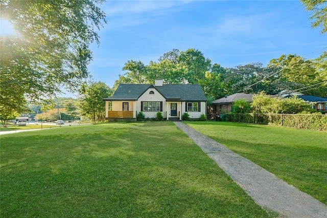 view of front of property with a chimney and a front lawn