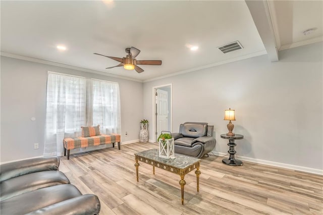 living room featuring ceiling fan, ornamental molding, and light wood-type flooring