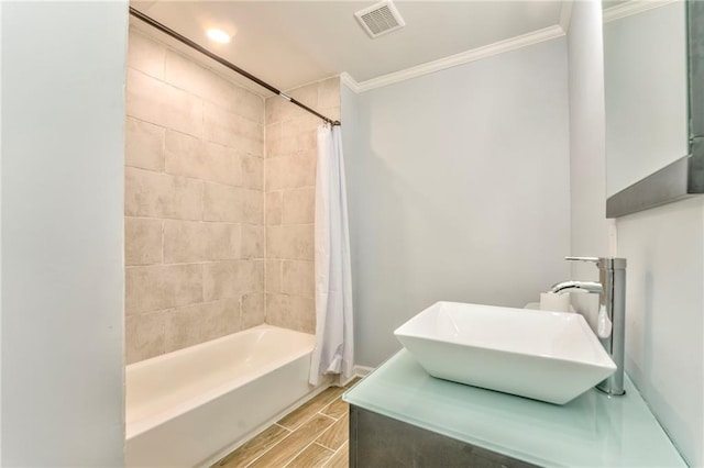 bathroom with crown molding, sink, and shower / tub combo with curtain