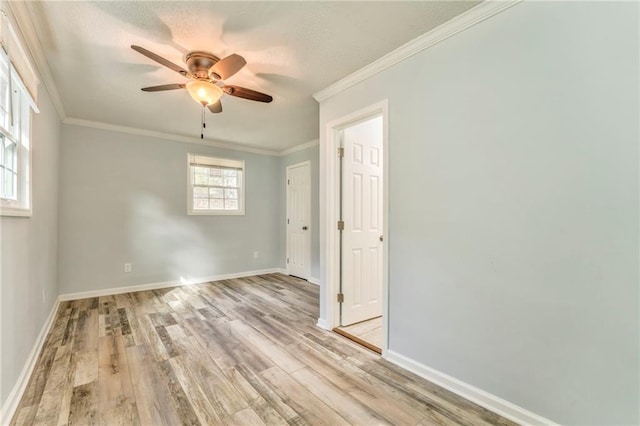 empty room with crown molding, ceiling fan, and light hardwood / wood-style flooring