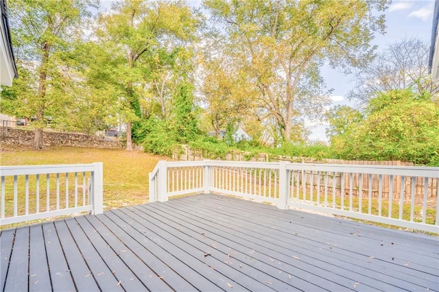 wooden deck featuring a lawn