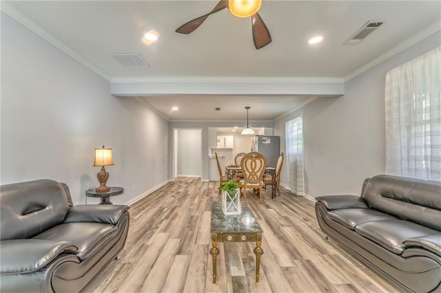 living room featuring crown molding, ceiling fan, and light hardwood / wood-style flooring