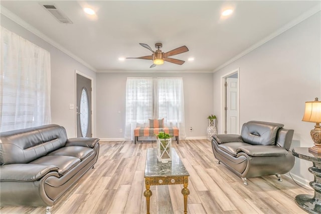 living room featuring ornamental molding, ceiling fan, and light wood-type flooring