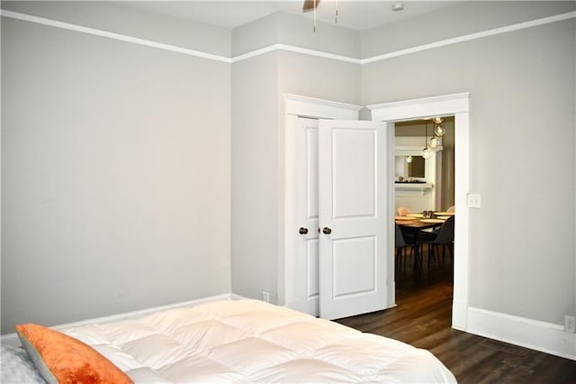 bedroom with dark wood-type flooring and a closet