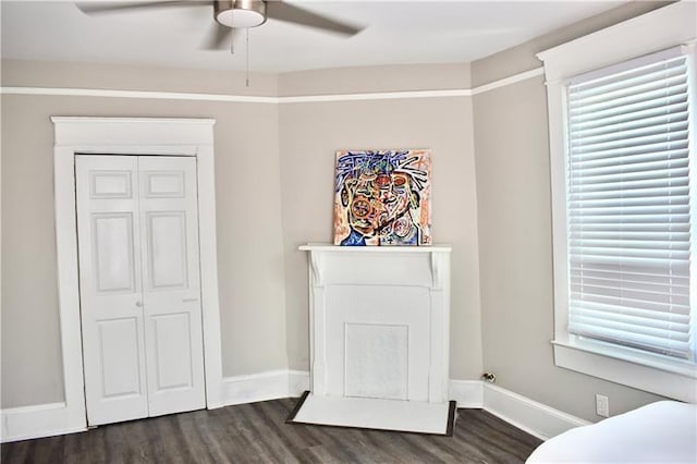 bedroom featuring ceiling fan, dark hardwood / wood-style floors, and a closet