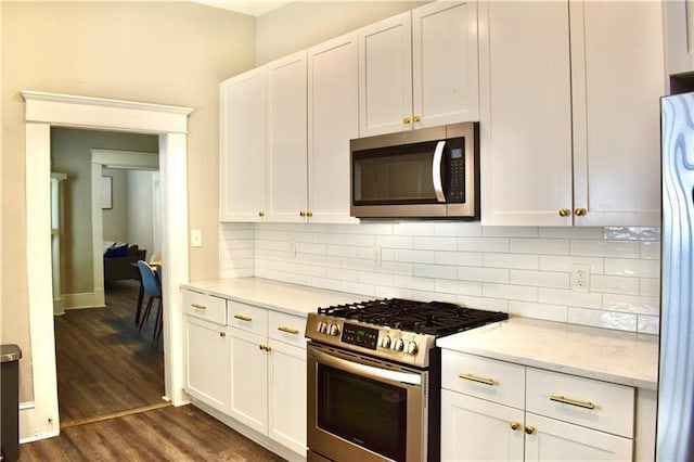 kitchen with white cabinetry, tasteful backsplash, stainless steel appliances, and light stone counters