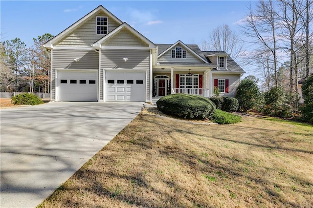 view of front facade with a porch, concrete driveway, a front lawn, and a garage