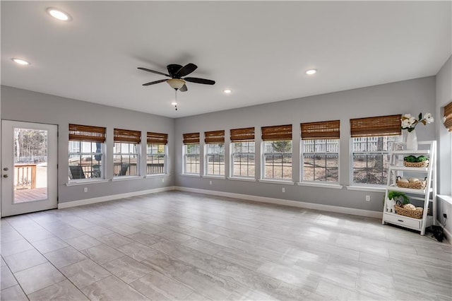 unfurnished sunroom featuring ceiling fan