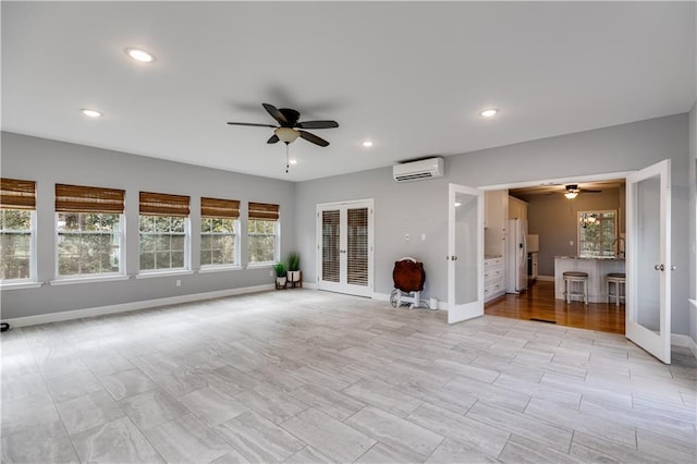 unfurnished living room featuring recessed lighting, an AC wall unit, and french doors