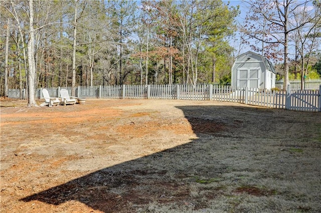 view of yard featuring an outbuilding, fence, and a storage shed