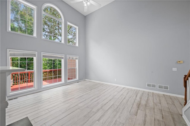 2595 Glaramara Ter, Cumming, GA 30041 - unfurnished living room featuring a ceiling fan, wood finished floors, baseboards, and a high ceiling