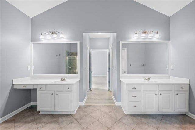 2595 Glaramara Ter, Cumming, GA 30041 - full bathroom with vaulted ceiling, a stall shower, two vanities, and baseboards