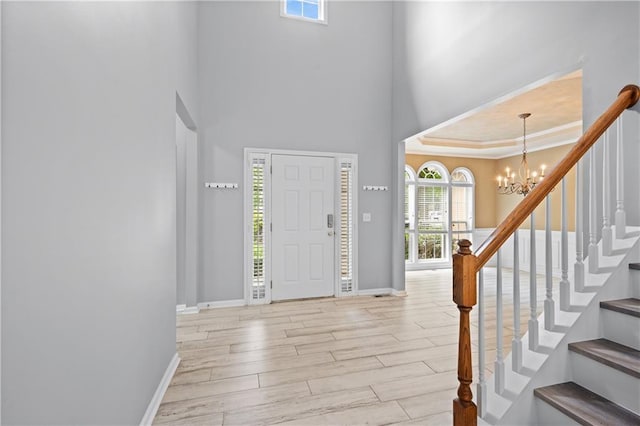 2595 Glaramara Ter, Cumming, GA 30041 - foyer with a chandelier, light wood finished floors, baseboards, a high ceiling, and stairway